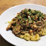 Geschnetzeltes Stroganoff Art mit Nockerl serviert auf einem weißen Teller, garniert mit frisch gehackter Petersilie.