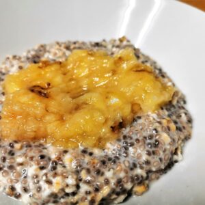 Overnight-Chia-Oats in einem weißen Teller mit zerdrückter Banane.